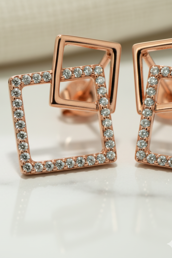 Rose gold square earrings with clear gemstones on a light background